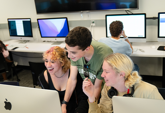 image of three summer pre-college students surrounding a computer